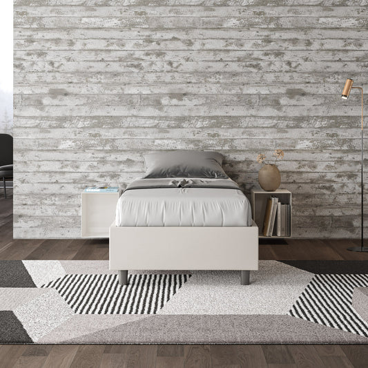 Letto singolo Azelia in similpelle bianca con rete, inserito in ambiente moderno. Perfetto per arredamenti contemporanei.