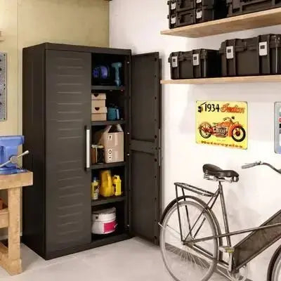Mobiletto alto Keter Detroit XL in resina antracite, utilizzato in un garage per riporre attrezzi, vernici e accessori.