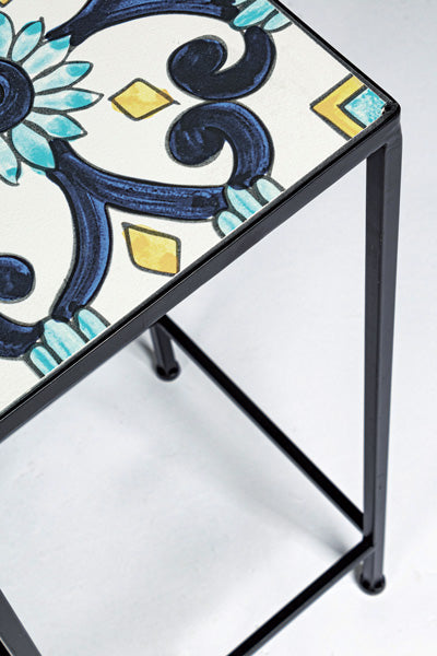 Dettaglio del ripiano in ceramica decorata con motivi floreali del set 3 tavolini da esterno in ferro, stile elegante e durevole.