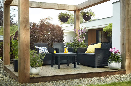 Set salotto Alabama Graphite con cuscini grigi sotto pergolato in legno, arredo da esterno elegante per giardino moderno