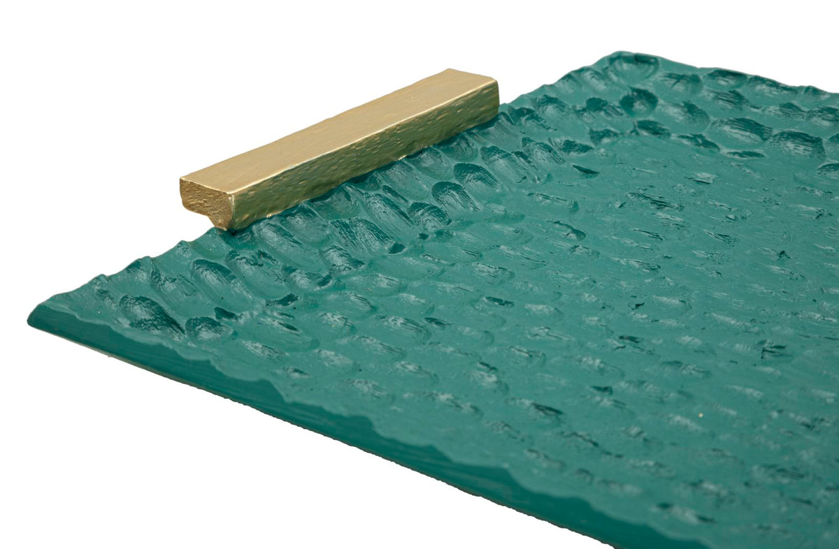 Particolare del manico dorato del vassoio Grent, superficie verde martellata per un tocco di eleganza funzionale.