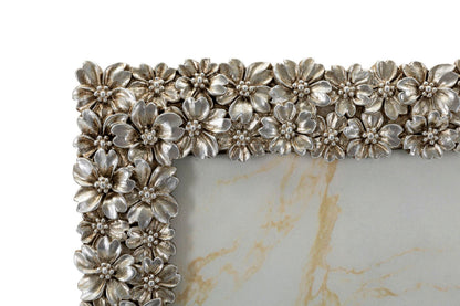 Dettaglio ravvicinato della Cornice Flowy Cm 26,2X1,7X31 con fiori in rilievo argentati, ideale per valorizzare fotografie 20x25 cm.