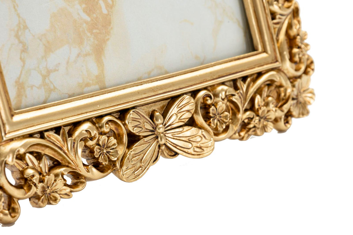 Particolare della cornice barocca dorata con farfalla decorativa e motivi floreali, design elegante per foto 15x20 cm.