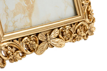 Particolare della cornice barocca dorata con farfalla decorativa e motivi floreali, design elegante per foto 15x20 cm.