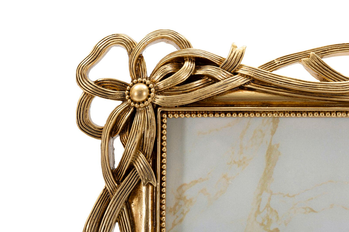 Particolare dell’angolo superiore della Cornice Knot con fiocco intrecciato dorato, design sofisticato per foto 20x25 cm.