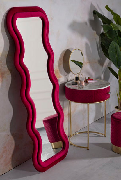 Specchio Emily 60x6x160 cm appoggiato a parete in un angolo make-up elegante, con cornice fuxia in velluto e arredamento coordinato.