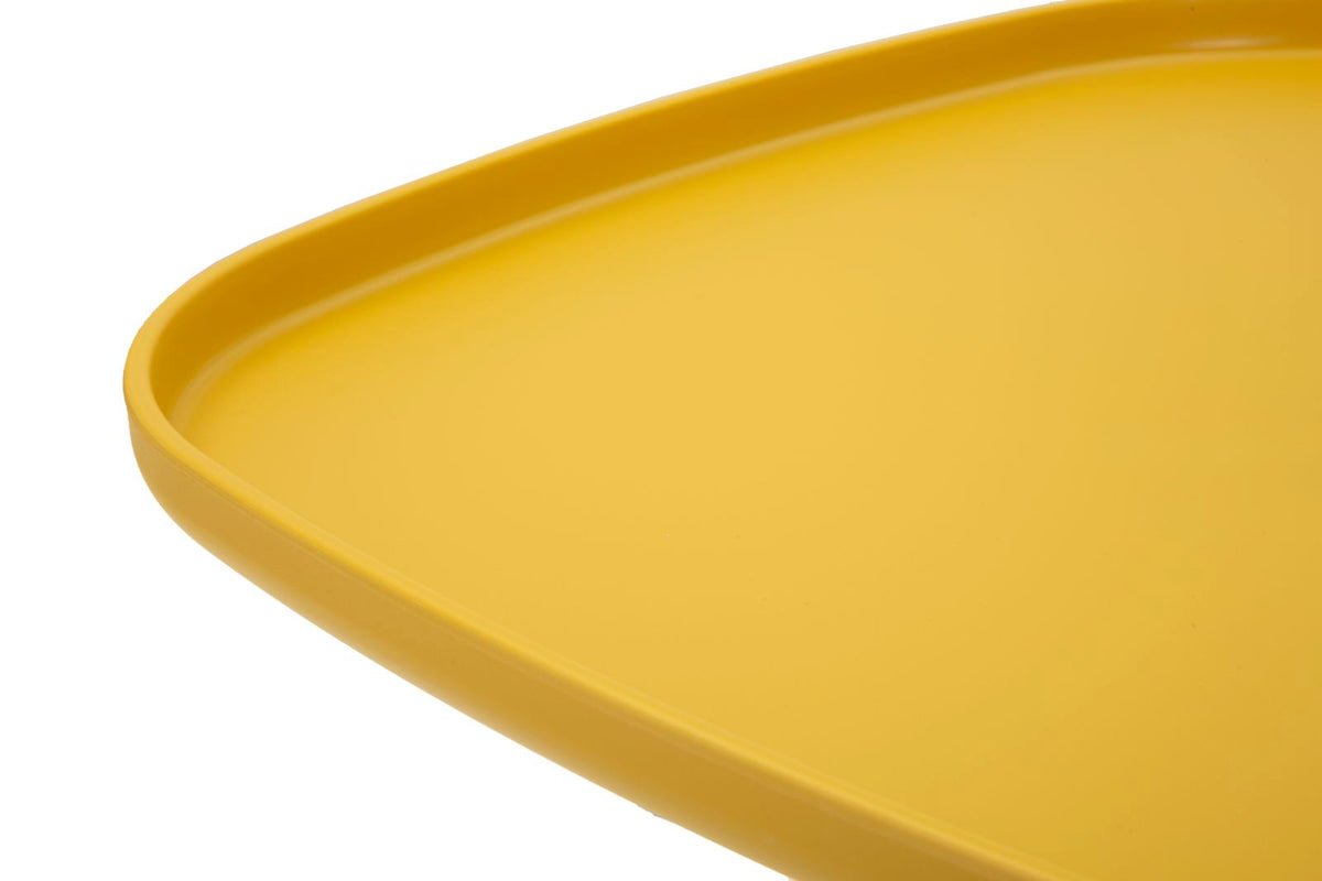 Dettaglio del bordo rialzato del tavolino giallo moderno, pensato per evitare la caduta di oggetti e facilitare la pulizia.