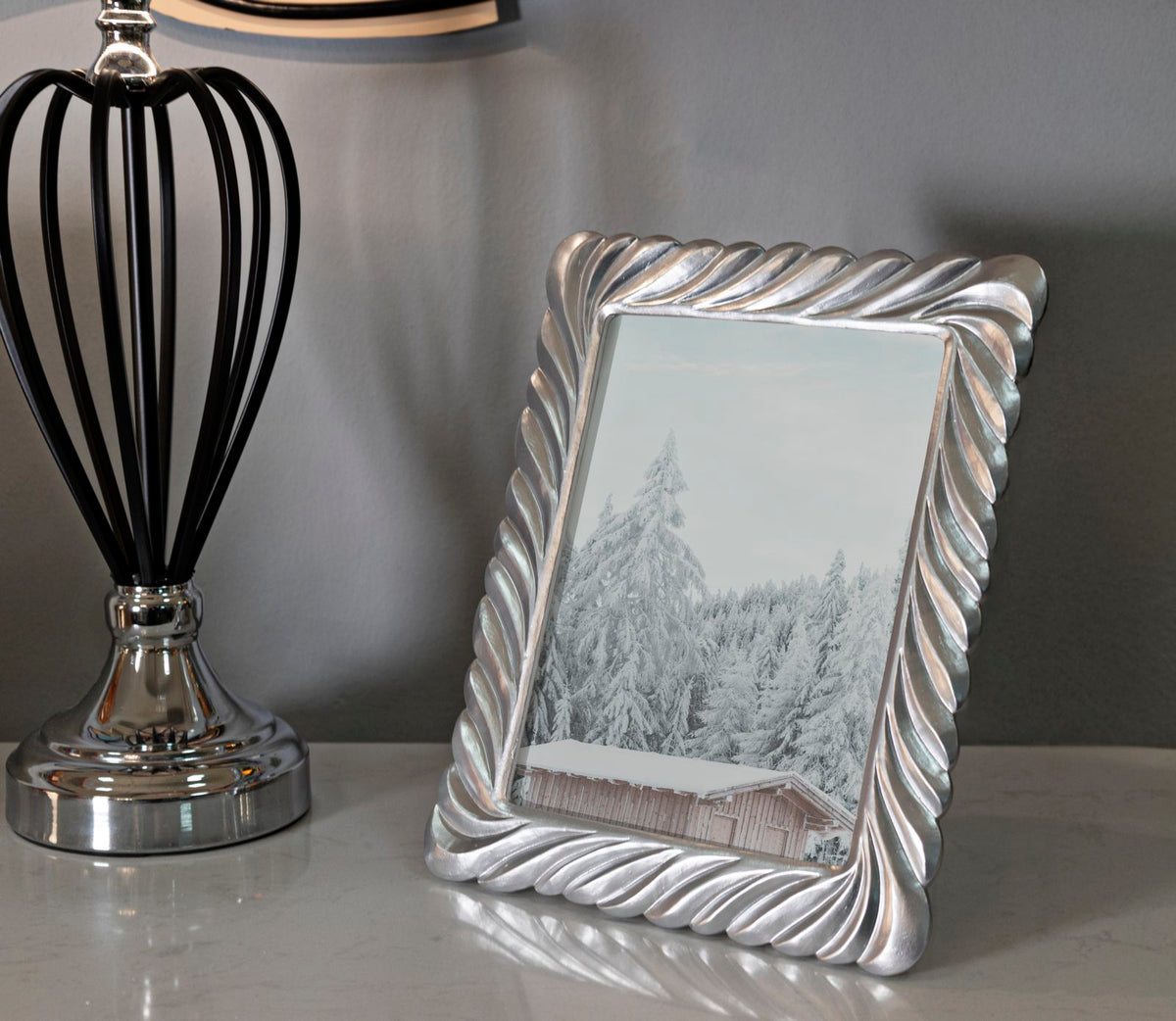 Cornice Carvy Cm 21,3X1,5X26,3 esposta su tavolo moderno, perfetta per decorare ambienti con foto 15x20 cm in stile elegante.