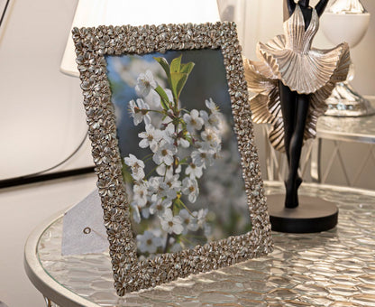 Cornice Flowy Cm 26,2X1,7X31 con foto floreale, esposta su tavolo moderno, ideale per decorare interni con stile romantico.