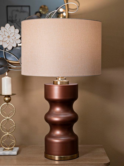 Lampada Tavolo Rosenthal accesa su mobile in legno, perfetta per ambienti eleganti con decorazioni di design.