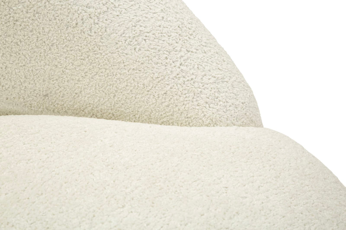 Dettaglio della poltrona Ginevra Bianca con rivestimento in tessuto bouclé beige, ambientazione con lampada e piante in stile scandinavo