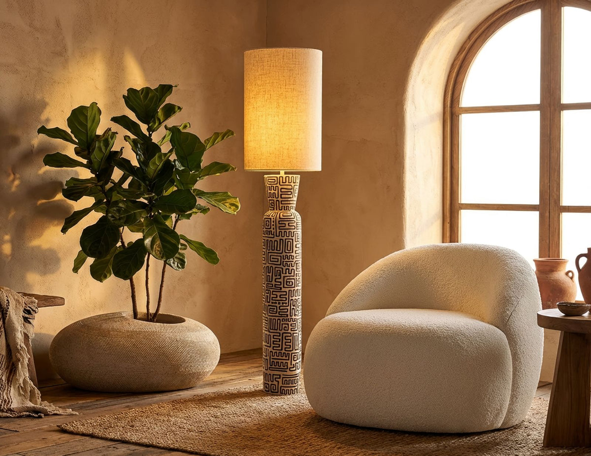 Interno living con poltrona Ginevra Bianca, arredamento minimalista in tonalità neutre, camino acceso e atmosfera calda e accogliente
