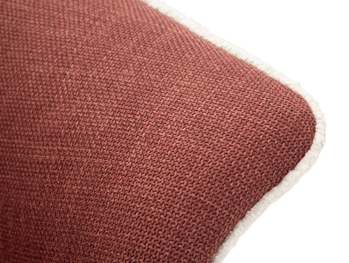 Particolare del bracciolo della Poltrona Girevole Siena Bordeaux con bordo bianco, tessuto resistente e raffinato.