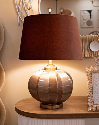 Lampada da tavolo Praga -A- Elegante Ø 40,5x57 posizionata su mobile in legno, ideale per arredamento d'interni con design raffinato.