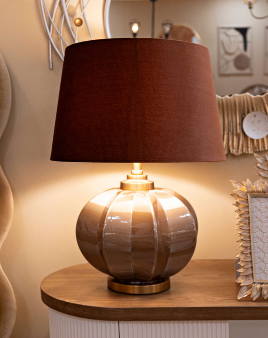 Lampada da tavolo Praga -A- Elegante Ø 40,5x57 posizionata su mobile in legno, ideale per arredamento d'interni con design raffinato.