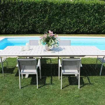 Set di poltrone Zante bianche attorno a un tavolo da esterno vicino a una piscina, perfetto per arredare giardini.