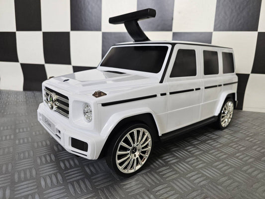 Particolare della parte superiore della valigia per bambini Mercedes, con finestrini neri e dettagli in plastica bianca, stile auto di lusso.