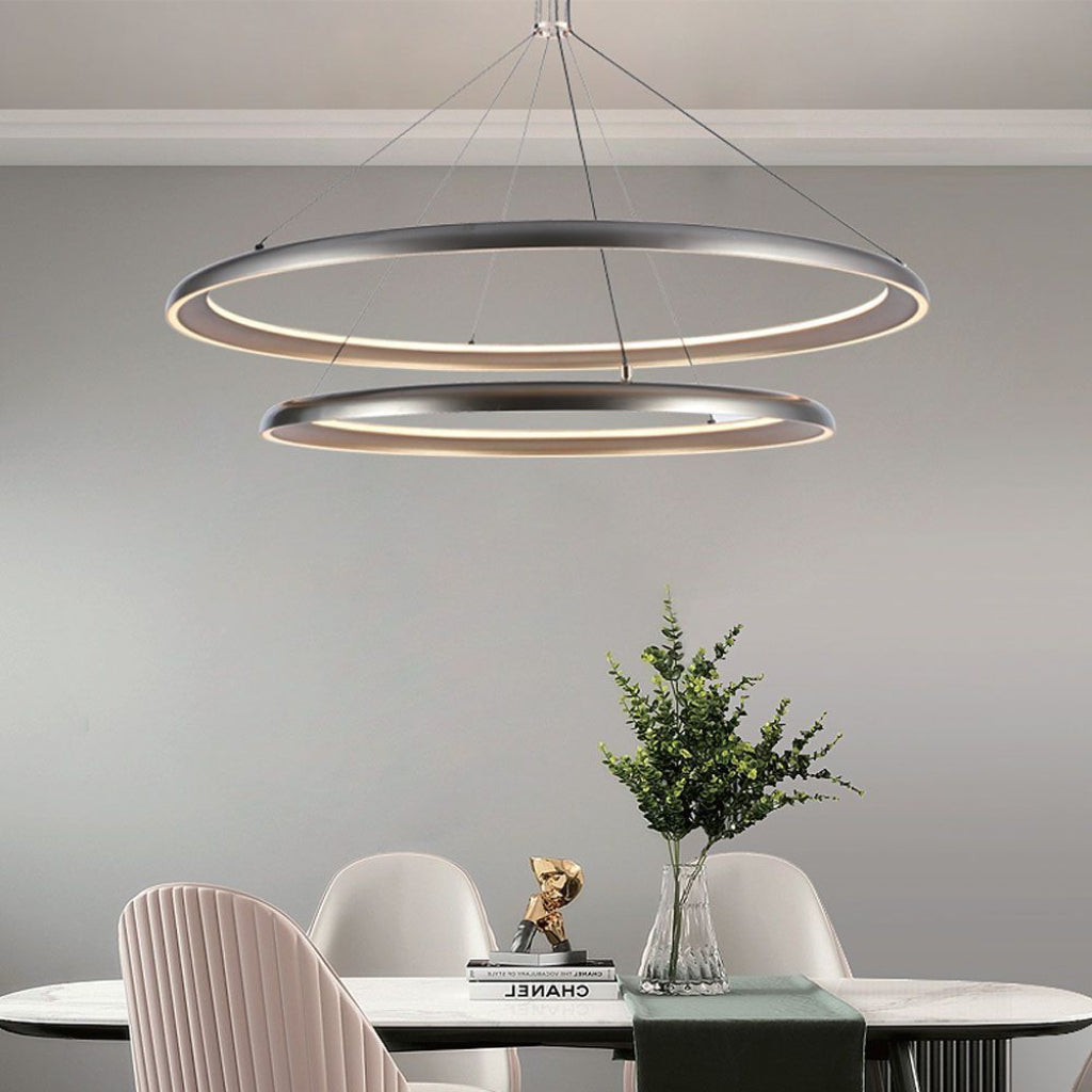 Lampadario LED moderno 65W grigio champagne 3000K installato sopra tavolo da pranzo, perfetto per ambienti raffinati e moderni.
