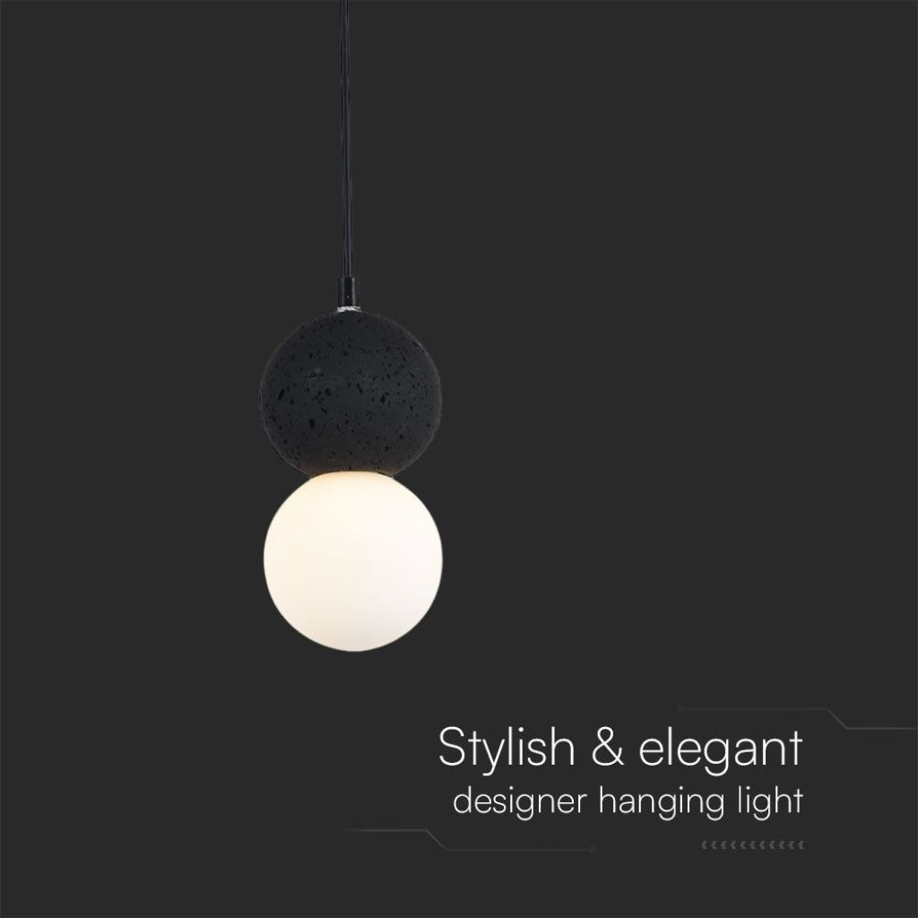 Lampadario a sfere LED nero e bianco acceso in ambientazione domestica, illuminazione elegante e stilosa per ambienti moderni.