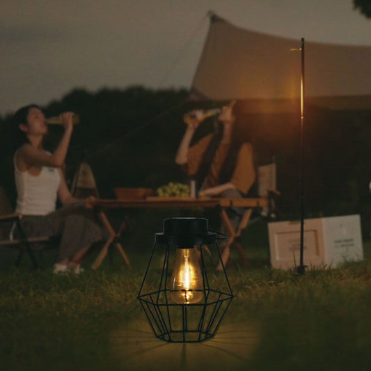 Lampada Solare LED da Terra 0.5W Vintage IP44 accesa in un campeggio serale, perfetta per ambienti outdoor e giardini.