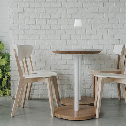 Lampada da tavolo bianca moderna con supporto sottile, posizionata su tavolo in legno, perfetta per illuminazione d'ambiente