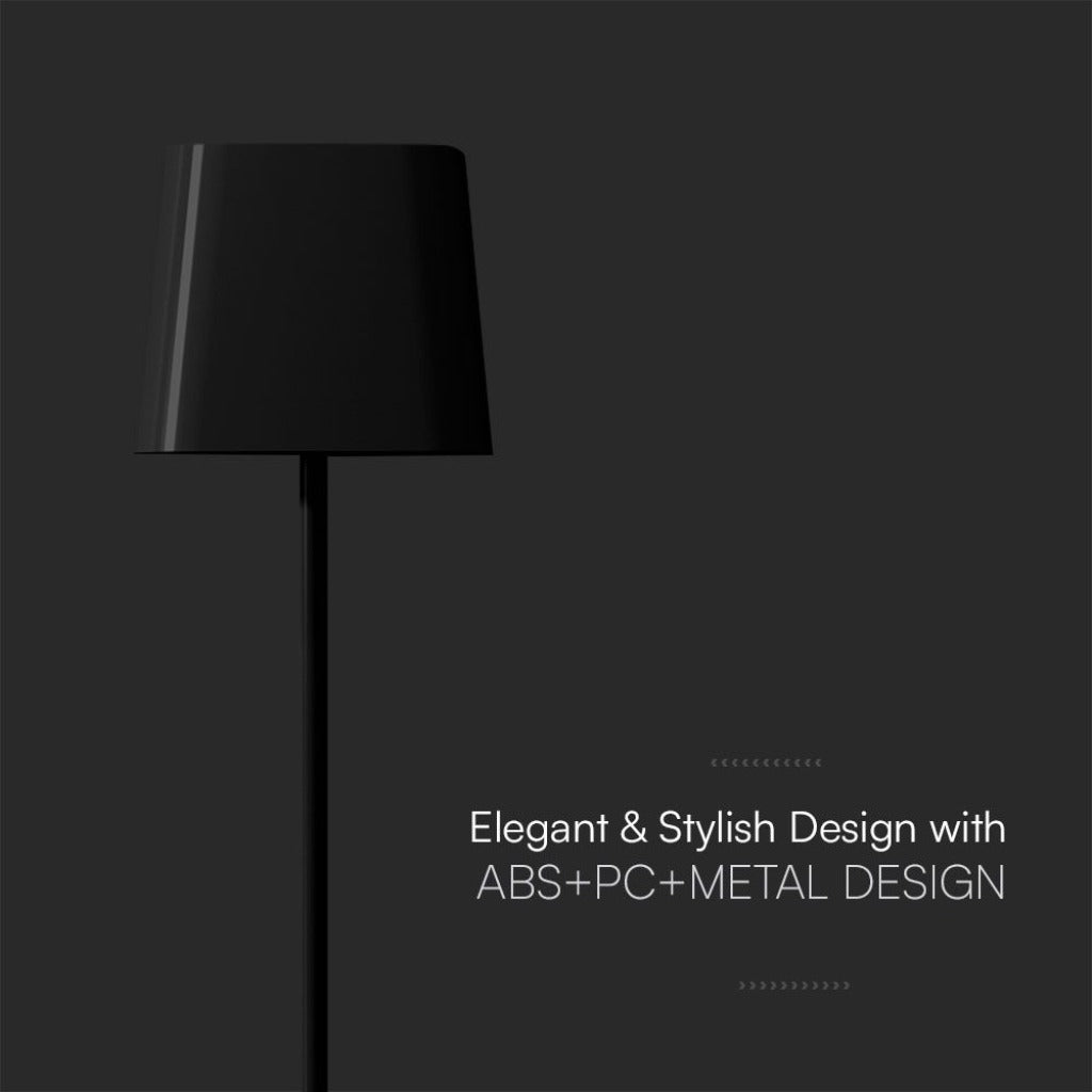 Immagine di una lampada da tavolo nera con design elegante e moderno, realizzata in ABS, PC e metallo, posizionata su una superficie di legno
