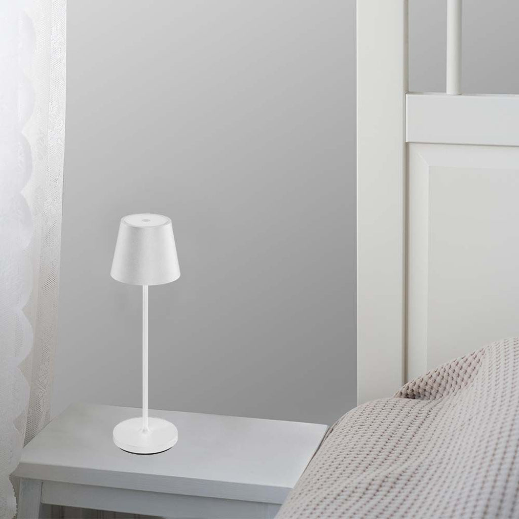 Lampada LED da tavolo bianca con design minimalista, perfetta per comodini in camere da letto moderne.