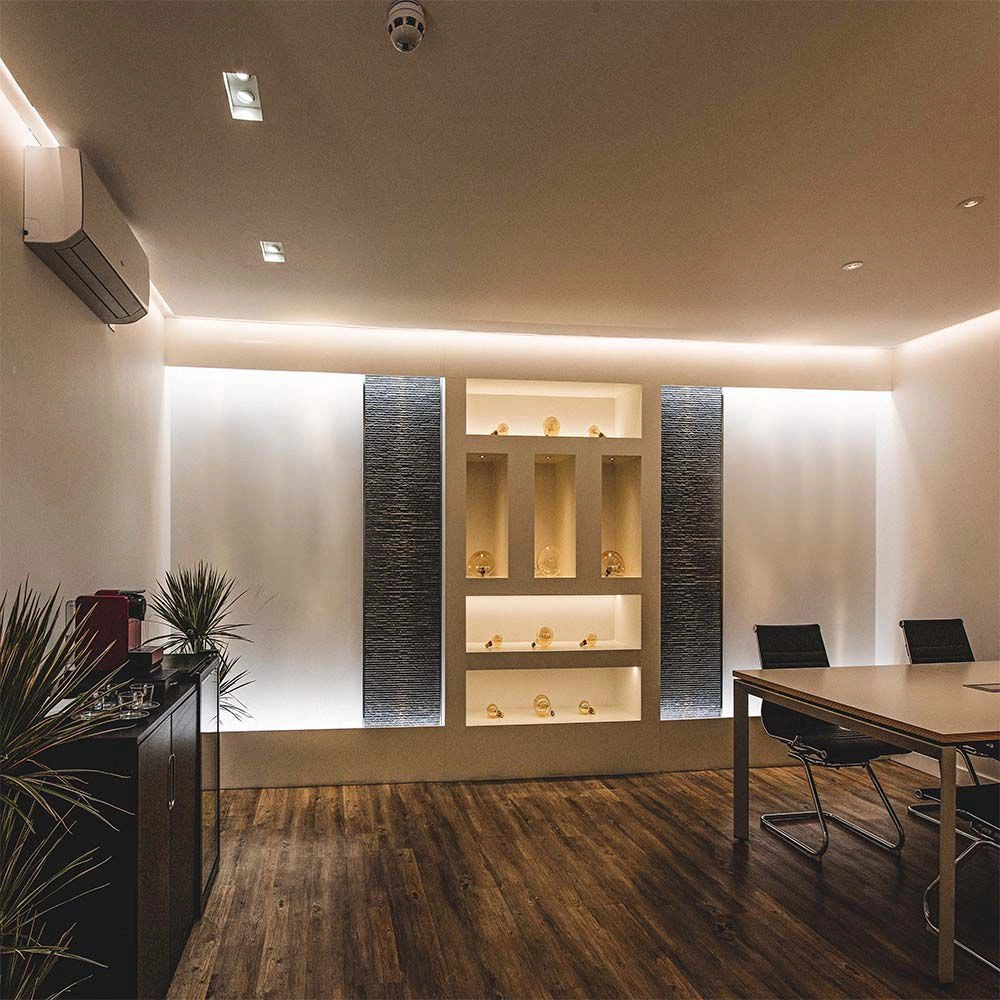 Strip LED 220V COB 3000K IP65 montata in soggiorno moderno, crea atmosfera accogliente con luce indiretta.