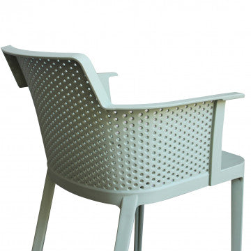 Dettaglio laterale dello schienale traforato della poltrona Cathy verde chiaro. Design moderno e ventilato.