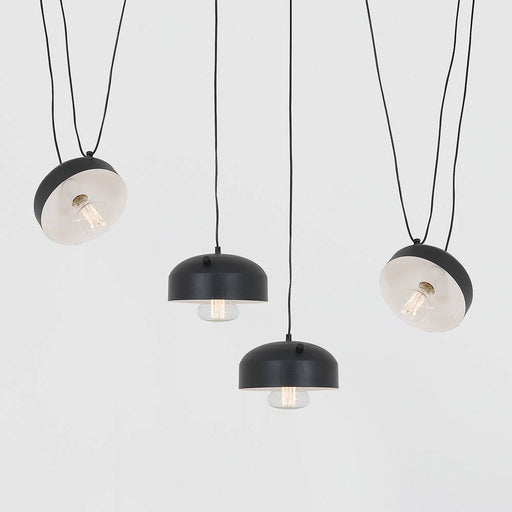 Dettaglio di lampade a sospensione nere con diffusori in vetro trasparente, stile industriale minimalista, perfette per ambienti moderni
