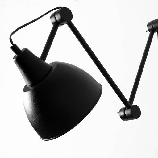 Dettaglio della lampada da parete nera Coben Wall con braccio articolato in metallo, stile minimalista e funzionale per ambienti creativi