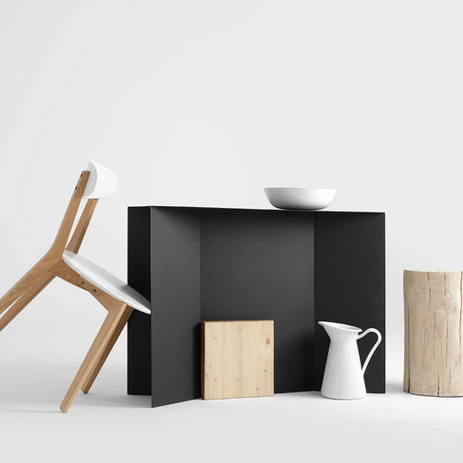 Console nera in metallo con superficie piatta e angoli netti, decorata con oggetti in ceramica e legno, stile moderno e semplice.
