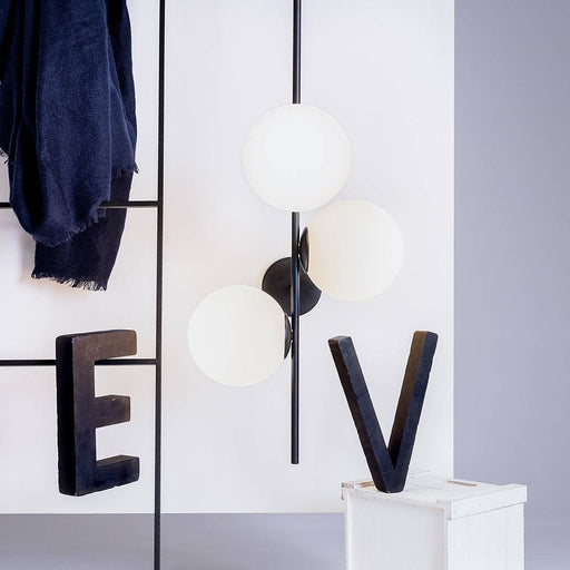 Dettaglio dell'applique BOBLER con globi di vetro bianco opaco e struttura nera, illuminazione elegante per ambienti moderni