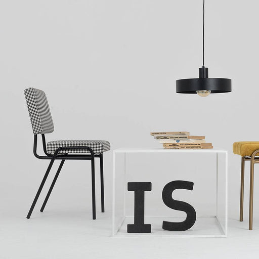Dettaglio della lampada Fay in acciaio verniciato nero con diffusore a sfera trasparente, ambientazione moderna con sedie e librerie