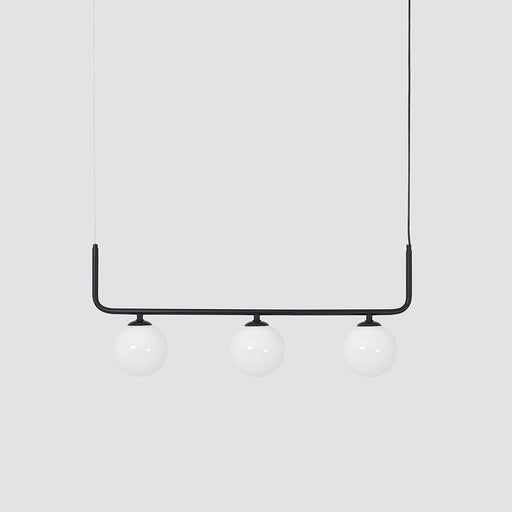 Lampada a soffitto Catkin 3 nera sopra soggiorno con plafoniera in vetro bianco e struttura in metallo nero, stile minimalista.