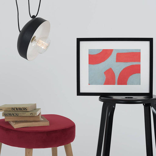 Lampada da soffitto industriale nera con interno bianco, illuminazione a vista, installata sopra un ambiente moderno con arredi minimalisti