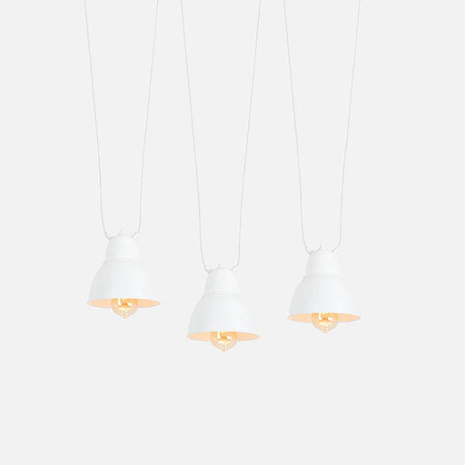 Immagine della lampada da soffitto bianca Coben con paralumi in metallo, sospesa in un ambiente luminoso e minimalista con parete bianca