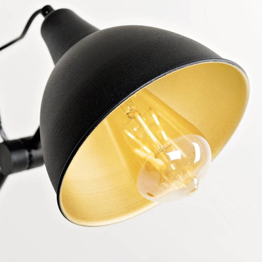 Dettaglio della lampada da terra Coben nera con diffusore giallo caldo, struttura in metallo e design minimalista, perfetta per ambienti moderni