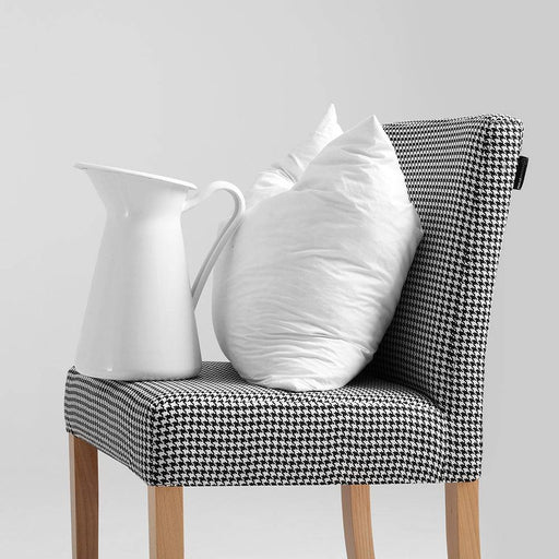 Sedia Wilton con rivestimento in tessuto a motivo pepita scuro, accompagnata da cuscini bianchi e brocca bianca, stile elegante e contemporaneo