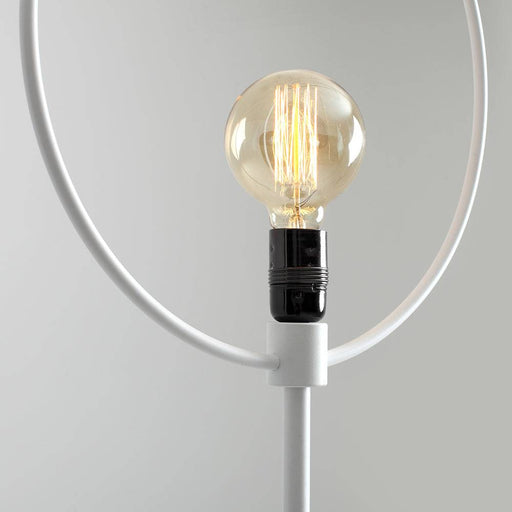 Dettaglio della lampada da terra bianca con lampadina a filamento visibile, stile moderno e linee pulite, ideale per illuminazione decorativa