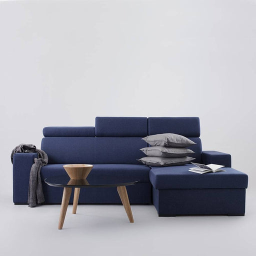 Immagine di un divano angolare in tessuto blu scuro, con dettagli di cuciture e struttura robusta, perfetto per ambienti contemporanei.