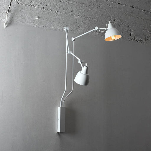 Lampada da parete bianca COBEN WALL 2 con bracci regolabili in stile industriale, installata su parete grigia, con cavo visibile