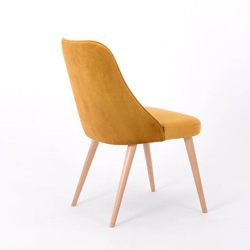 Vista laterale di poltrona in velluto senape con gambe in legno chiaro, stile contemporaneo e seduta comoda, ideale per ambienti domestici