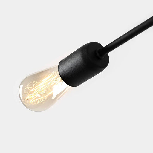 Dettaglio di lampadina a vista con finitura nera, design minimalista, perfetta per illuminazione decorativa in ambienti moderni