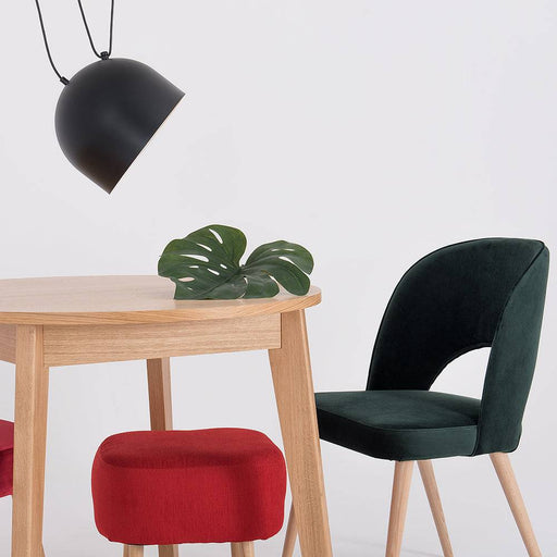Sedia BUKO in velluto verde bottiglia con struttura in legno chiaro, posizionata in ambiente con tavolo e lampada nera, SKU: CH007BUKO-RV38