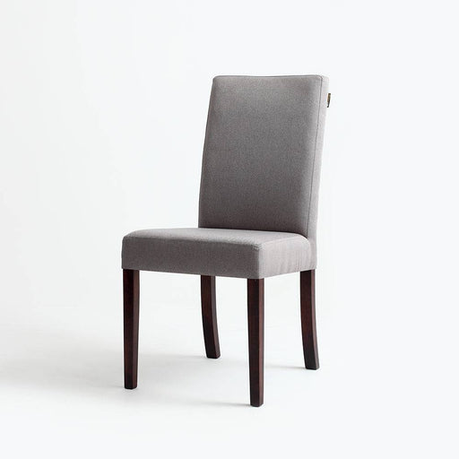 Dettaglio della sedia Wilton 98 con rivestimento in tessuto grigio, gambe in legno noce scuro, design raffinato e comfort elevato.