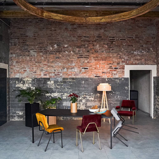 Set di sedie colorate in velluto rosso e senape con struttura in metallo nero, perfette per sala da pranzo o zona living di stile industriale