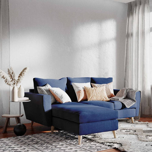 Divano angolare LOVER L in tessuto inchiostro, con cuscini decorativi beige e grigi, stile moderno e confortevole, ideale per soggiorno.