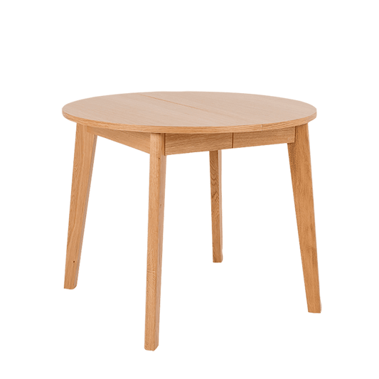 Tavolo da pranzo rotondo in quercia naturale con gambe inclinate, superficie liscia e design elegante, ideale per ambienti moderni e accoglienti.