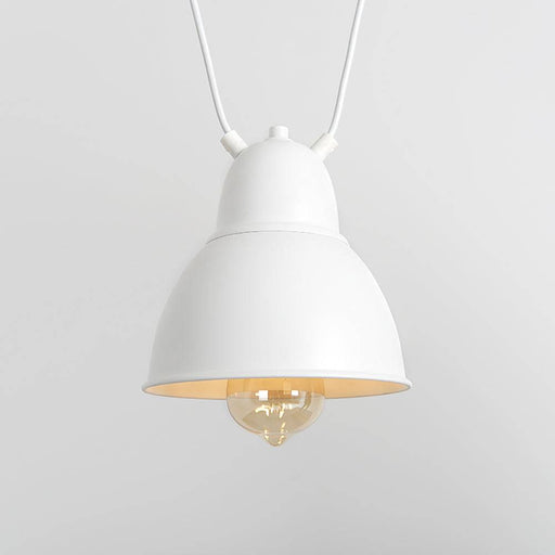 Dettaglio della lampada da soffitto bianca con diffusore in metallo e lampadina visibile, stile minimalista e versatile per interni